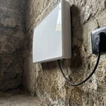 Dispositif anti-humidité installé sur un vieux mur en pierre gravement endommagé par l'humidité