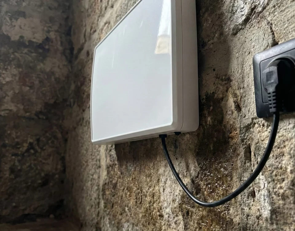 Dispositif anti-humidité installé sur un vieux mur en pierre gravement endommagé par l'humidité
