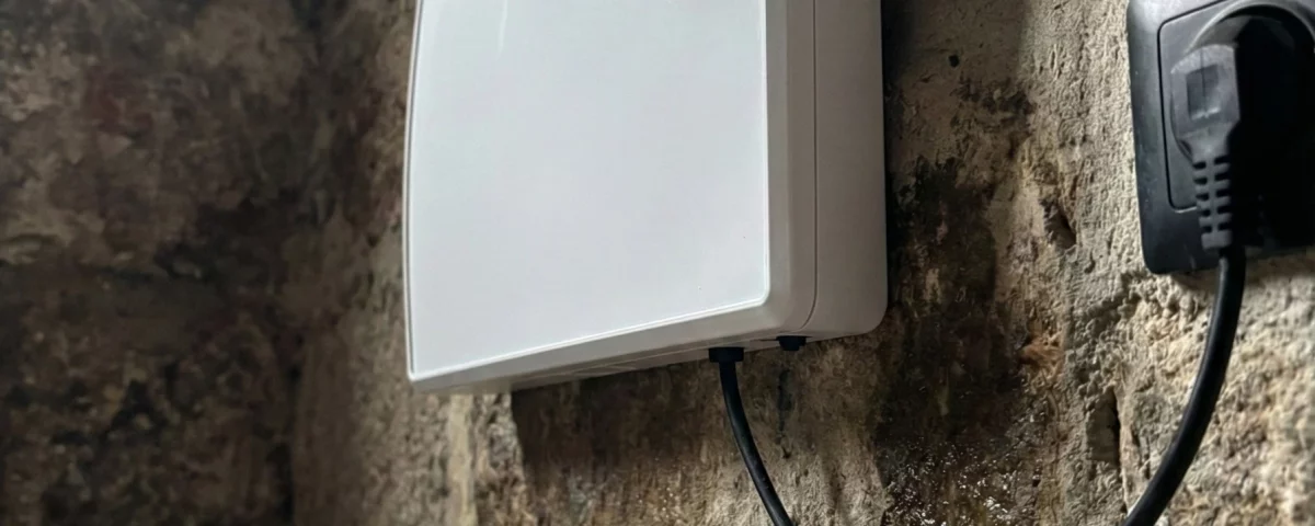 Dispositif anti-humidité installé sur un vieux mur en pierre gravement endommagé par l'humidité